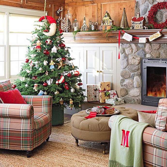 A rustic living room with bold Christmas decor   a red pillow, a berry wreath and a Christmas tree with catchy red and white ornaments plus a red garland with bold touches