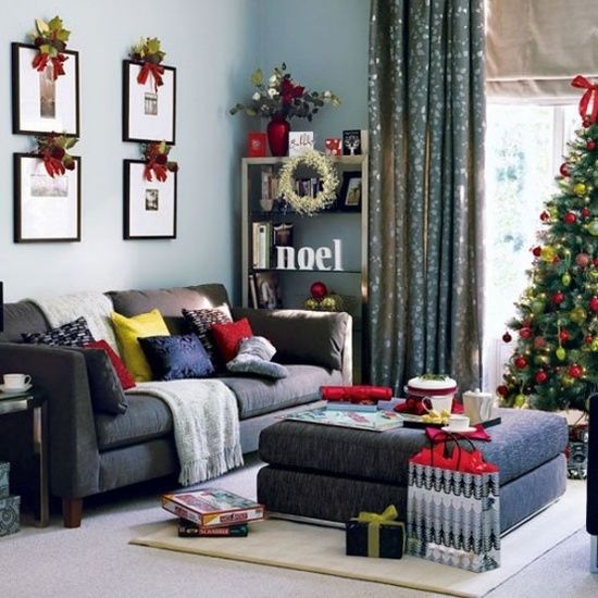 bold pillows, a gallery wall topped with greenery and berries, a Christmas tree decorated with red and green ornaments, some red touches here and there