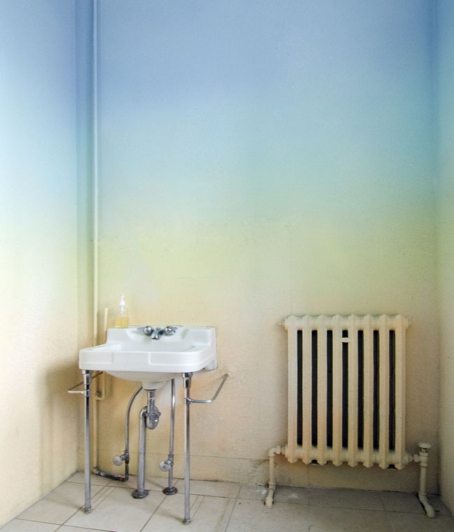 A usual bathroom turned super boldwith ombre blue to green, yellow and orange walls that just blow your mind