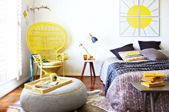 a fun spring boho bedroom with a yellow peacock chair, bold yellow touches, printed bedding and a bright artwork