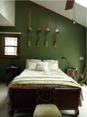 a vintage bedroom with dark wooden furniture, floral bedding, floral arrangements in vases and pendant lamps