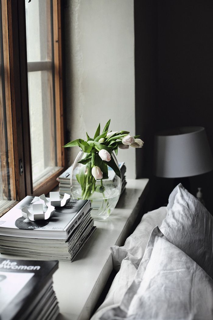 A Scandinavian bedroom in neutrals, with fresh blooms in a vase feels fresh and spring like