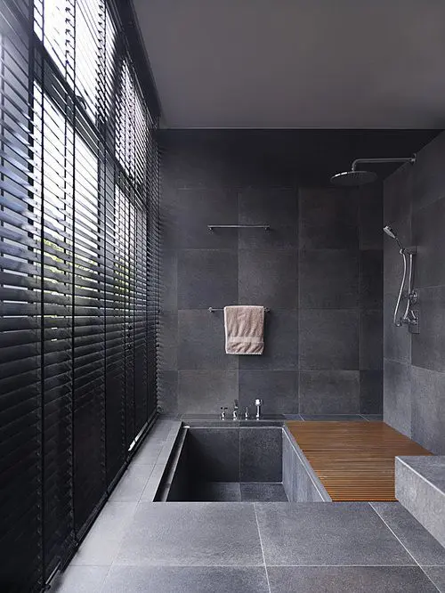 a minimalist tiled bathroom with a tiled sunken bathtub and a wooden mat is amazing for a contemporary space