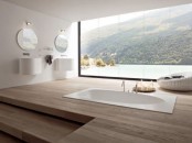 a large minimalist bathroom with a sleek wooden floor and a sunken bathtub plus a fantastic view through a panoramic window