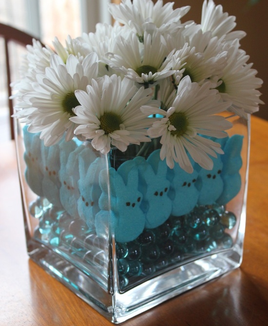 a simple white flower arrangement in a jar with blue beads and blue bunnies for Easter