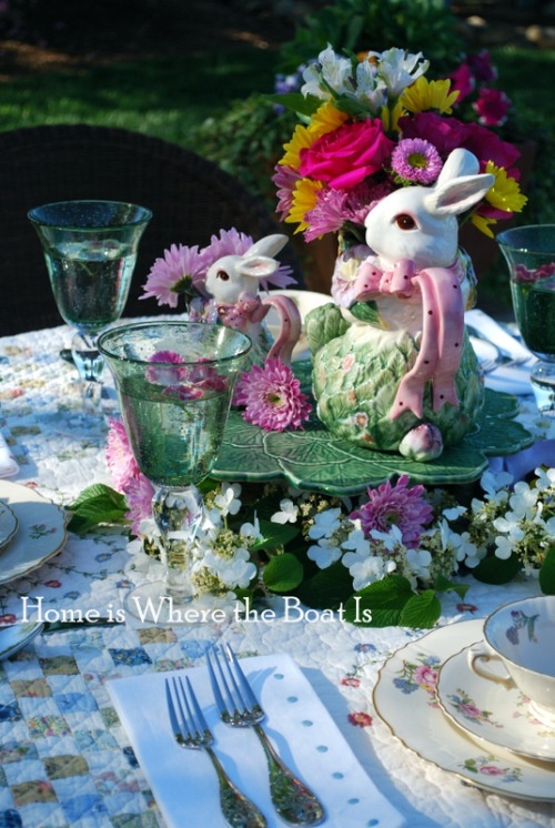 An Easter centerpiece of a leaf shaped bowl, lots of spring blooms and a flower arrangement on top