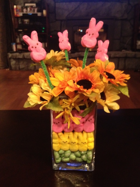 a clear vase filled with colorful bunnies and with bright blooms and bunnies on sticks for Easter