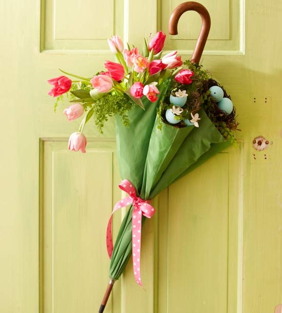 a green umbrella filled with pink tulips and a nest with blue eggs for Easter decor