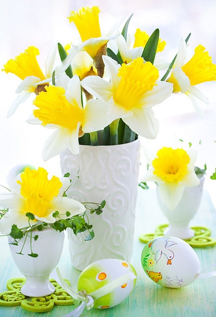 a vase and egg holders with yellow daffodils is a timeless Easter centerpiece idea