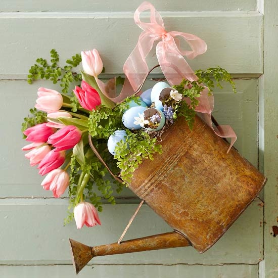 a vintage watering can with greenery, pink tulips and blue eggs for Easter decor