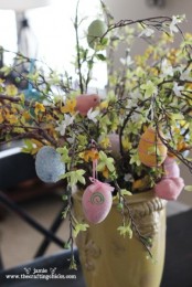 blooming branches with colorful fake eggs and birdies for Easter