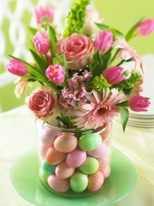 a bright floral arrangement with colorful eggs in the jar is a cool Easter decoration