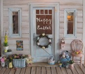 a pastel spring porch with a colorful egg wreath and basket, a basket with blooms and potted blooms