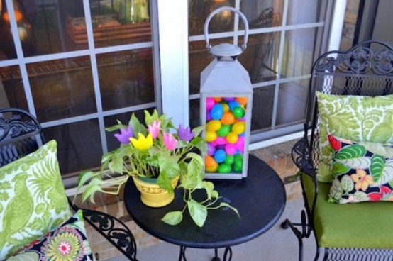 a large lantern filled with colorful eggs, colorful paper blooms in a basket for Easter