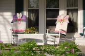two rocking chairs with bunny covers and a bright floral arrangement for Easter
