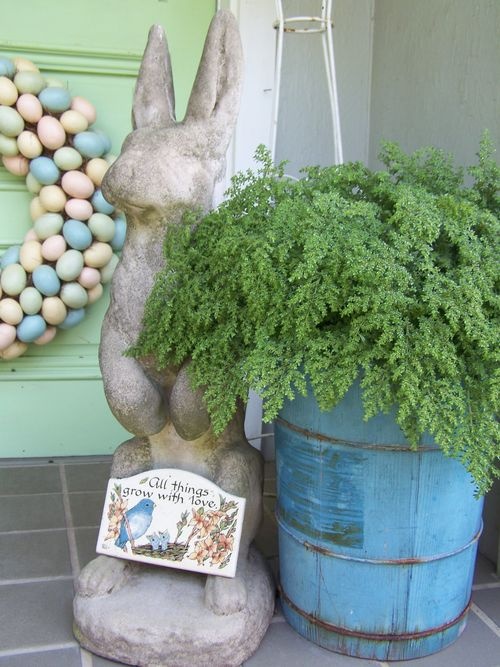 a blue wooden bucket with greenery, a colorful egg wreath and a vintage bunny for decor