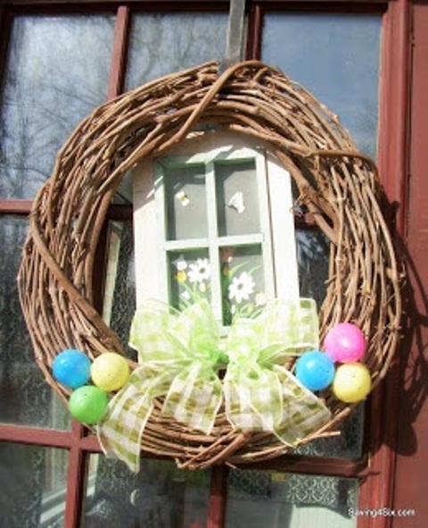 a spring wreath with colorful eggs, a bright bow and a vintage window piece with decor