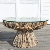 a unique dining table, the base of which is fully composed of driftwood and with a round glass tabletop is a fantastic solution and an eco-friendly decoration