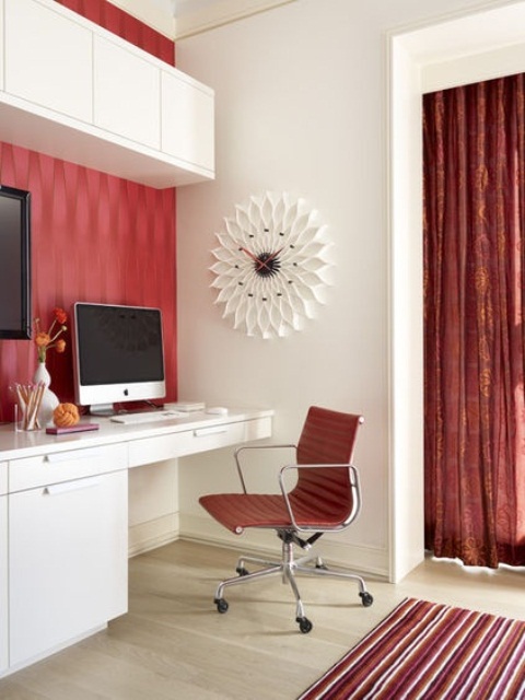 a bright red and white home office with printed red wallpaper, a curtain and a rug plus a red leather chair