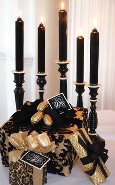 Elegant and refined black and gold Christmas decor   chic black candles in black and gold candleholders and black and gold gift boxes