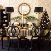a refined and chic Christmas tablescape with white blooms, black glasses and a black Christmas tree with lights and gold ornaments is ultimate chic and boldness you can enjoy