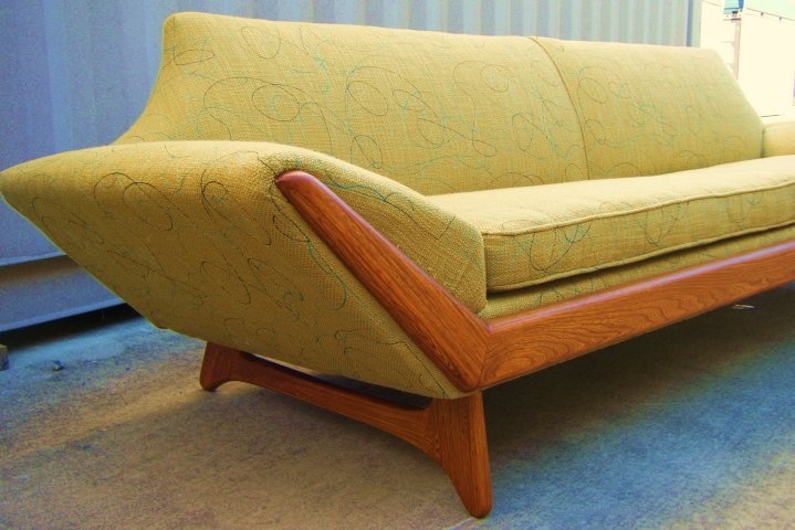 A yellow printed mid century modern sofa with a rich stained frame is a catchy and bold solution for a mid century modern living room