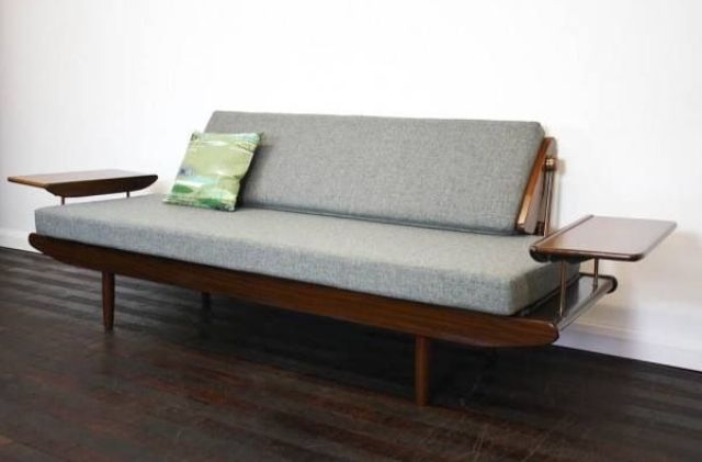 A grey mid century modern sofa with a dark stained frame and armrests is a catchy and bold idea for a mid century modern space
