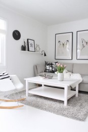 a cozy Scandinavian living room with arworks, comfy furniture, a grey rug and a black clock