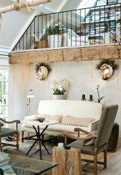 a French famrhouse living room with white and grey furniture, wood touches, potted blooms and greenery