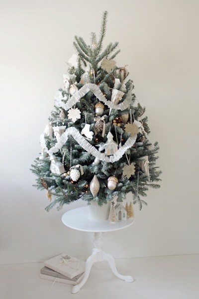 a snowy Christmas tree with white, silver and mother of pearl ornaments, garlands and mini lights