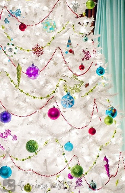 a white Christmas tree with super bright and colorful ornaments and garlands to contrast it for a bold look