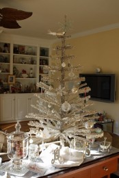 a shiny silver Christmas tree with white and silver ball and snowflake ornaments can be a nice tabletop decoration
