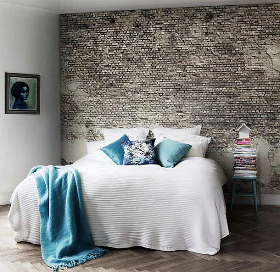 White bedding set contrast great against dark toned brick wall.
