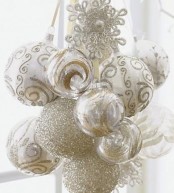 a cluster of white, clear and gold Christmas ornaments is a beautiful decor idea that will suit both a vintage and a modern Christmas space