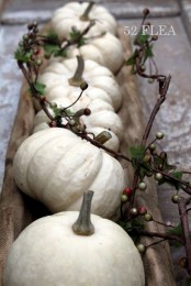 a wooden dough bowl with white pumpkins and berries is a nice fall centerpiece or decoration