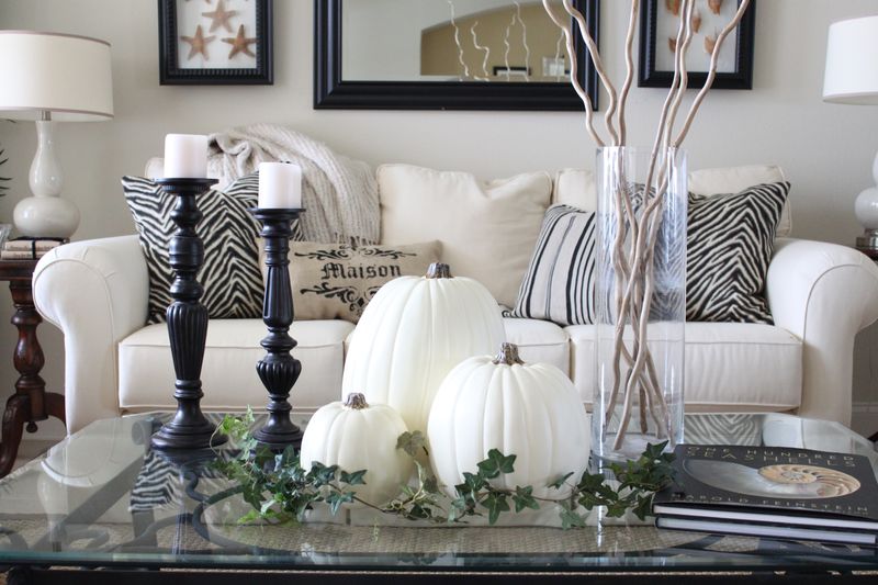 White pumpkins, white candles in black candleholders and greenery for a chic vintage inspired coffee table display