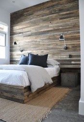 a statement headboard wall fully clad with weathered wood and a matching wooden slab bed for a cozy rustic look