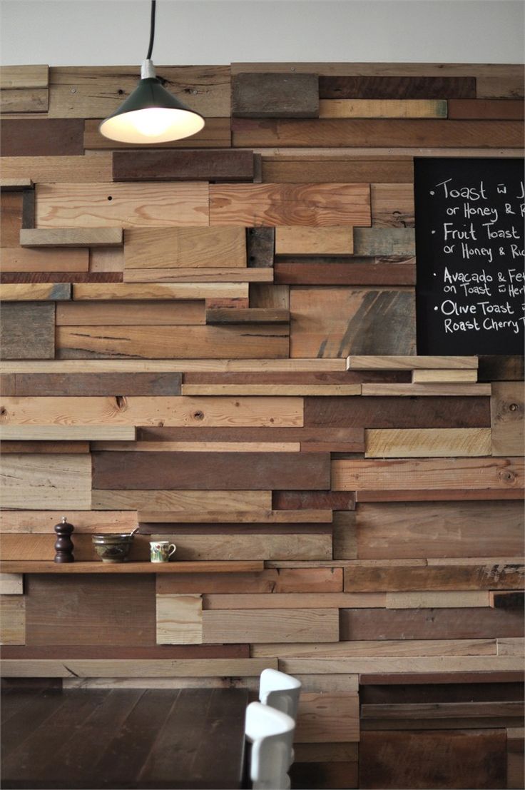 A unique accent wall done with lots of wooden slabs and planks in various colors adds a rustic and industrial touch