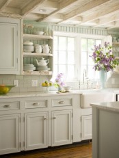 a neutral vintage kitchen with pane cabinets, a white stone countertops, a white subway tile backsplash, mint green backsplash and open shelves is cool