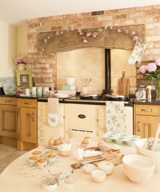 a beautiful vintage kitchen with warm-stained cabinets, black coutnertops, a vintage cooker, touches of pink and floral textiles