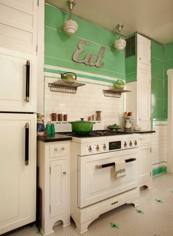 a contrasting vintage kitchen with green walls and white cabinets, a penny tile floor, a white tile backsplash and black touches
