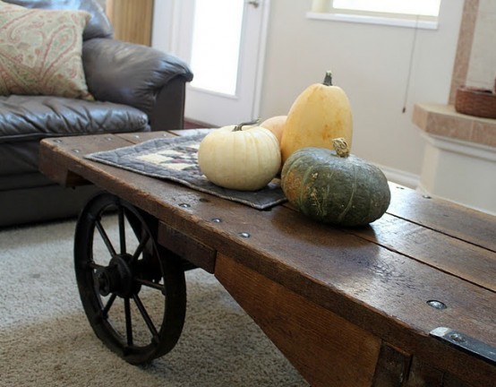 an uncovered coffee table with three natural pumpkins is a cool rustic option for fall home decor