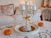a fall coffee table with pumpkins and a tray with colorful pebbles and a candelabra for a cool and chic look