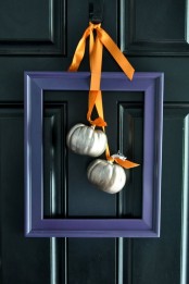 a modern alternative to a fall wreath – a purple frame with metallic pumpkins and orange ribbons is very stylish and bold