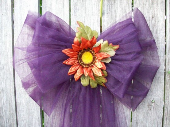 a purple tulle bow with bright blooms is a bright alternative to a fall wreath and will last long