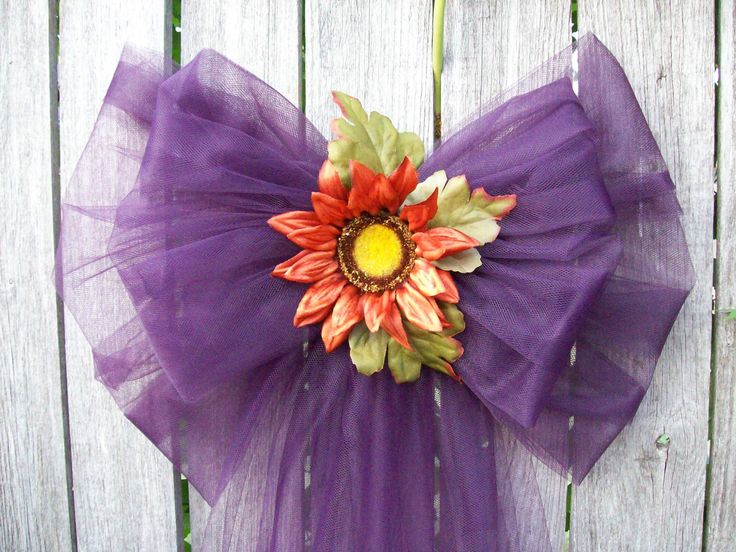 A purple tulle bow with bright blooms is a bright alternative to a fall wreath and will last long