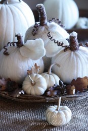 white faux, knit and crocheted pumkins, acorns and leaves compose an unusual and very cozy fall centerpiece