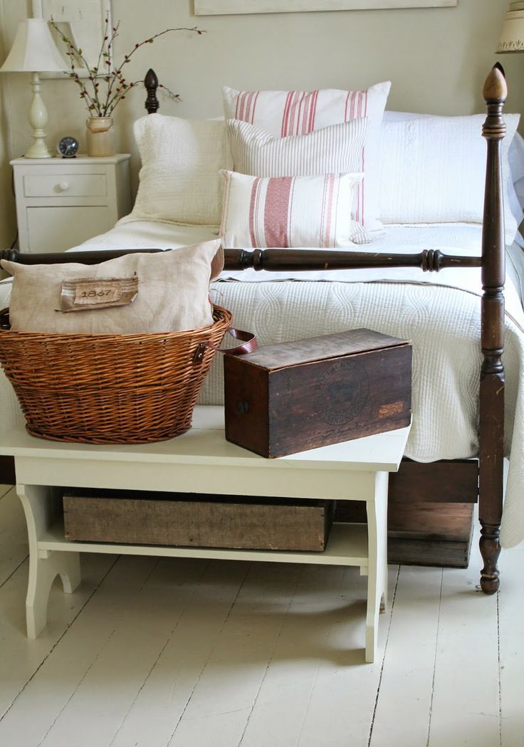 a farmhouse bedroom done with whitewashed wood, vintage painted and stained furniture and boxes and baskets