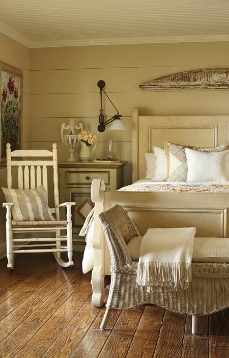 a neutral vintage farmhouse bedroom with vintage furntiure, artworks and lamps