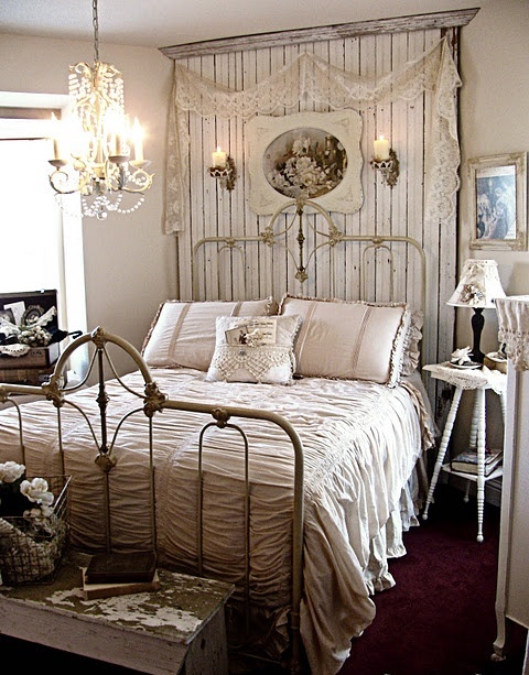 an exquisite vintage farmhouse bedroom with whitewashed furniture, lamps and chests, lace and artworks 